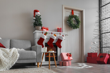 Obraz premium Interior of living room with wooden door, fireplace, sofa and Christmas decor