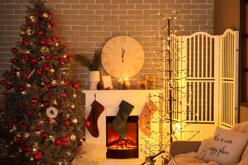 Interior of dark living room with fireplace, clock and glowing Christmas tree