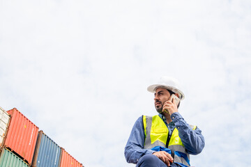 A male specialist engineer is on the phone with an employee of a container shipping company. Logistics global cargo container concept.