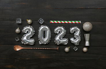 Figure 2023 made of balloons with bartender's supplies on black wooden background