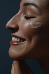 Young beautiful happy woman applying cream on her face