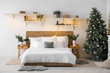 Interior of bedroom with Christmas tree, shelves and glowing lights