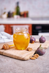 Honey in a glass jar or pot on kitchen table