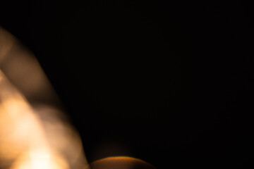 Blur colorful gold crystal light leaks on black background. Defocused abstract red and orange retro film lens flare bokeh analog photo overlay or screen filter effect. Glow Vintage prism warm colors