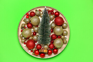 Table setting with Christmas tree and balls on green background