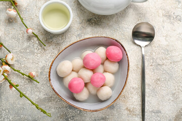Bowl of tangyuan, cup and sakura on grunge background. Dongzhi Festival