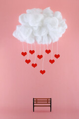 Cloud of falling hearts over a park bench on a pink background