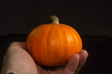 Yellow-orange pumpkins on a black background the concept of Halloween and the autumn harvest of pumpkin close-up copyspace from above