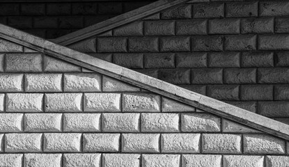 Brick vintage textured wall with diagonal shapes in a black and white abstract photo great for background. Lights and shadows.