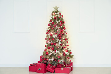 Glowing Christmas tree with presents near light wall