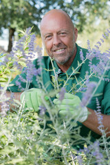 professional gardener looking at camera over spring garden background