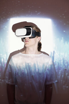 Portrait of young male model using VR set standing in cosmic projector light 