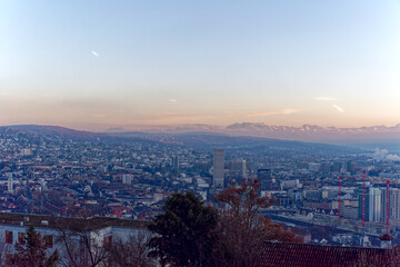 Fototapeta na wymiar Aerial view over City of Zürich with Limmat River and Swiss Alps in the background on a sunny autumn evening. Photo taken December 6th, 2022, Zurich, Switzerland.