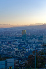 Aerial view over City of Zürich with skyscraper Prime Tower and Swiss Alps in the background on a sunny autumn evening. Photo taken December 6th, 2022, Zurich, Switzerland.