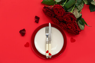 Fototapeta na wymiar Table setting for Valentine's Day with hearts and roses on red background