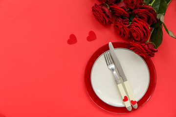 Table setting for Valentine's Day with hearts and roses on red background
