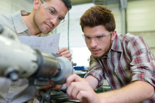 portrait of smiling instructor with trainee in workshop