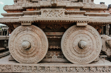 Wheels of Medieval stone chariot and ancient archeological ruins at Hampi, Karnataka, India. unesco world heritage site. closeup