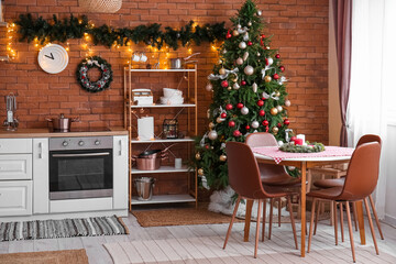 Interior of kitchen with Christmas tree, glowing lights and dining table