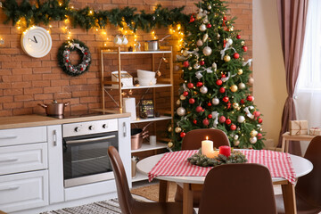 Dining table with Christmas wreath and candles in kitchen
