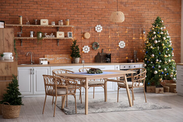 Interior of kitchen with glowing Christmas trees, dining table and counters