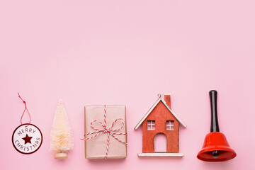 Gift with Christmas bell and toys on pink background