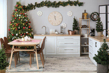 Interior of kitchen with Christmas trees, dining table and big clock