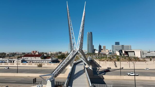 Skydance Bridge with view of Oklahoma City skyline. OKC on sunny day, aerial view of traffic on interstate highway road.