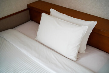 ホテルのベッドに置かれた整えられた2つの枕