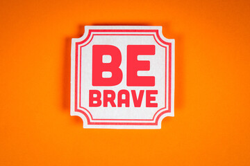 BE BRAVE. Sticky note with text on a orange background