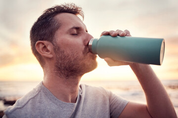 Man, fitness and water bottle with sunset beach background for thirst, hydration and healthy lifestyle while outdoor for exercise, workout and training. Male athlete drinking refreshment in nature