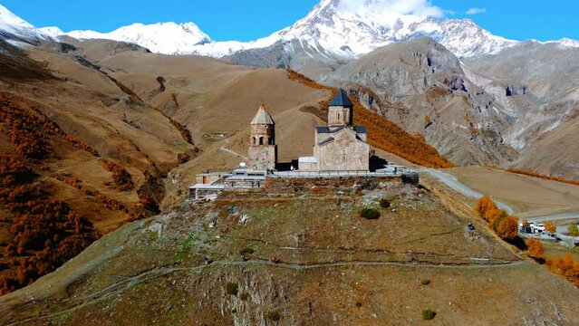 Drone view of famous Gergeti Trinity Tsminda Sameba Church In Autumn in Mount Kazbegi. Stepantsminda, Georgia country
