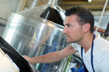 concentrated man checking work results on beer factory