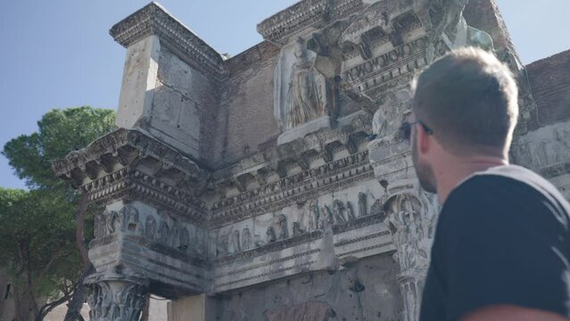 Caucasian Man In Sunglasses Turn Around And Look Up On The Colonnacce Of The Forum Of Nerva In Rome, Italy. low angle