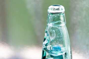 太陽に照らされてキラキラ光る青いラムネ瓶