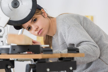 female apprentice in carpentry class using circular saw