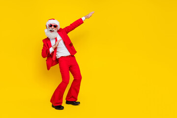 Full length photo of positive excited santa dressed red suit tie having fun dancing discotheque empty space isolated yellow color background