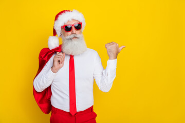 Photo of elegant person indicate thumb finger empty space x-mas proposition isolated on yellow color background