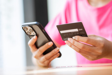 online payment Asian woman hands holding credit card and using smartphone for online shopping.