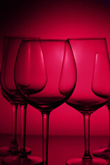 Set of wine glasses on dark viva magenta background close up