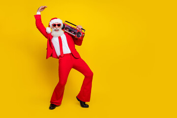 Fototapeta na wymiar Full length photo of cool funky claus wear red tux costume having fun listening boom box empty space isolated yellow color background