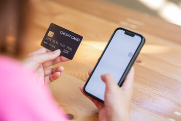 online payment Asian woman hands holding credit card and using smartphone for online shopping.