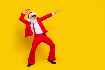 Fototapeta na wymiar Full length photo of cool attractive retired guy wear red tux claus hat having fun empty space isolated yellow color background