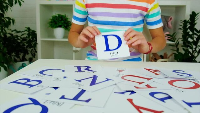 English cards are taught by children at the table. Selective focus.