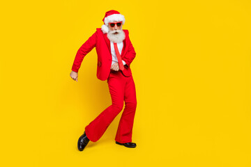 Fototapeta na wymiar Full length photo of funky cool retired guy wear red tux claus hat dancing empty space isolated yellow color background