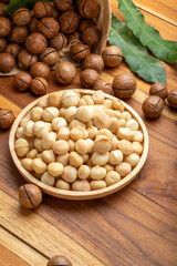 Macadamia nut in wooden plate on wooden background, Roasted Macadamia nuts on wooden background.
