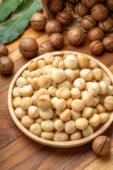 Roasted Macadamia nut in wooden plate on wooden background, Macadamia nuts on wooden background.