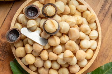 Roasted Macadamia nut in wooden plate on wooden background, Macadamia nuts on wooden background.