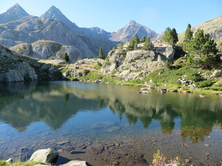 Paysage de montagne avec un lac et les montagnes qui se reflètent dans l'eau.