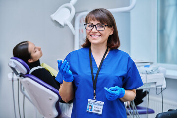 Portrait of female dentist with girl patient sitting in dental chair